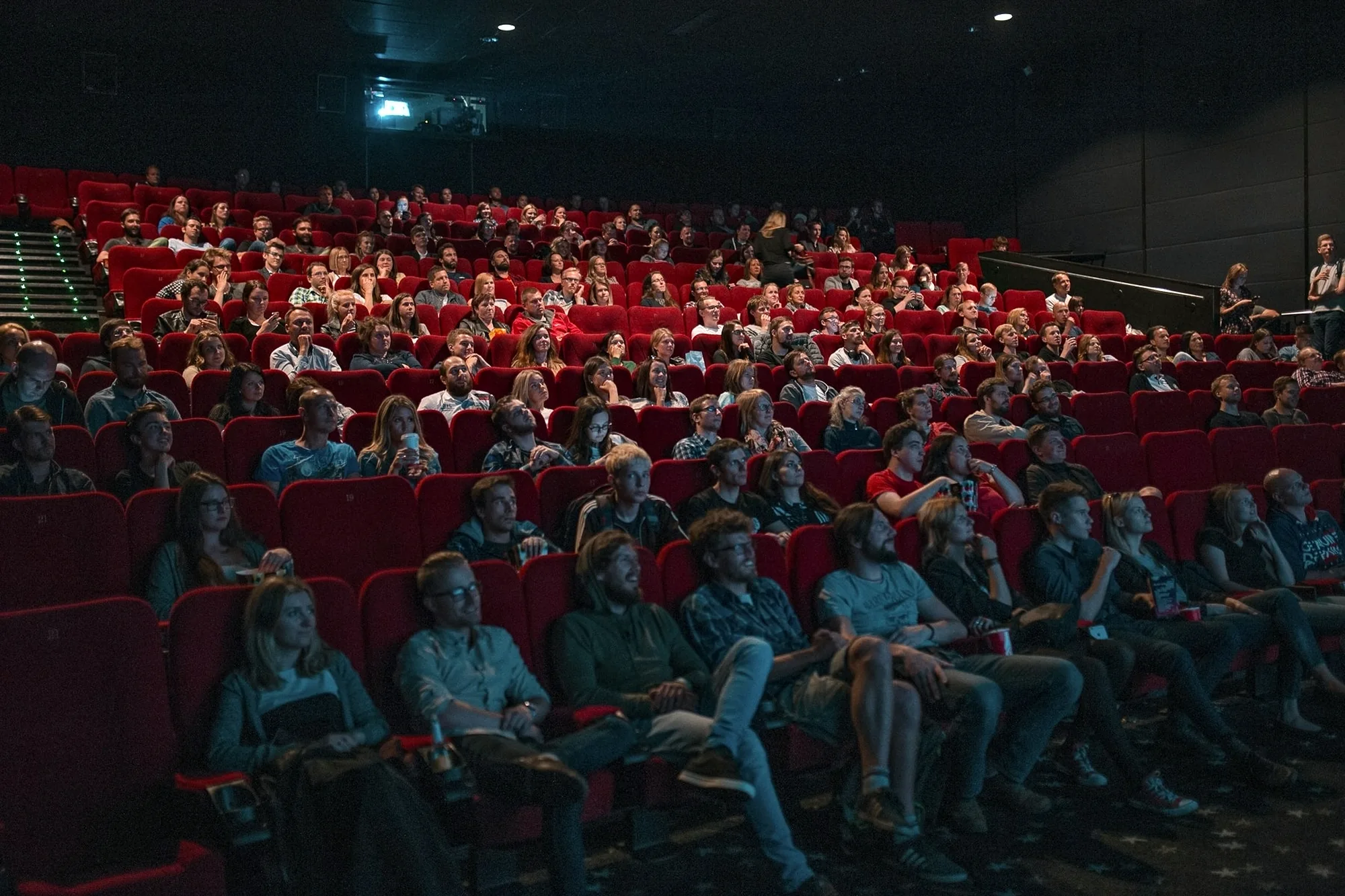 A full cinema auditorium, the audience watching in the dark.